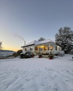 una casa nella neve con le luci accese di Mystic Twistic a Vîrfurile