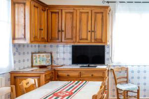 una cucina con armadi in legno e un tavolo con televisore di Appartement Handia ad Amotz