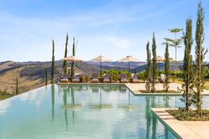 una piscina con sillas y sombrillas en Hotel Borgo Del Vino, en Areal