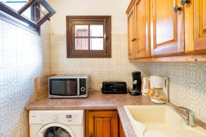 una cucina con forno a microonde, lavatrice e lavandino di Appartement Handia ad Amotz Altre 13 foto