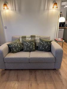 eine Couch mit Kissen darauf in einem Wohnzimmer in der Unterkunft Poets View - Studio in Honington, Suffolk in Honington