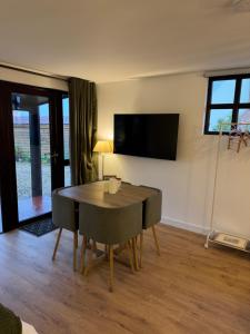 ein Esszimmer mit einem Tisch und einem TV an der Wand in der Unterkunft Poets View - Studio in Honington, Suffolk in Honington + 18 Fotos