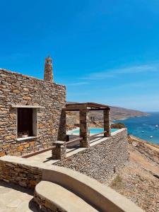 a stone house with a stone wall and a patio at Conte Kea in Koundouros +12 photos