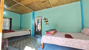 Arman homestay mawlynnong في Mawlynnong: غرفة بسريرين وعلب على الحائط