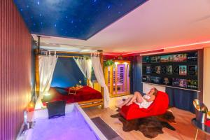 a woman sitting in a red chair in a room at Twilight Star Spa - Sauna & Private Cinema - Free Parking in Amiens