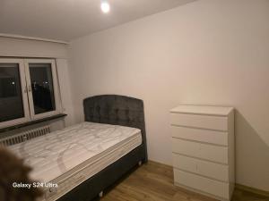 a bedroom with a bed and a dresser and a window at Wohnung in maintal in Maintal