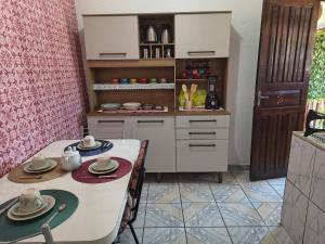 a kitchen with a table and chairs and a counter at Chalé da Elba 01 Ilhabela in Ilhabela