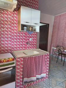 een keuken met een rode en witte muur met patronen bij Chalé da Elba 01 Ilhabela in Ilhabela +13 foto's