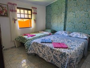 twee bedden in een kamer met blauwe muren bij Chalé da Elba 01 Ilhabela in Ilhabela