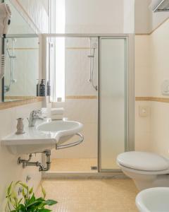 ein Badezimmer mit zwei Waschbecken und einer Toilette in der Unterkunft Acapulco Hotel in Cattolica