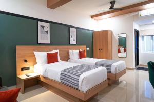 Un dormitorio con dos camas y una pared verde. en Olive Hotel Hitec City by Embassy Group, en Hyderabad 38 fotos más