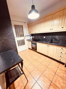 a kitchen with wooden cabinets and a black counter top at La Osera in Arroyo Frio