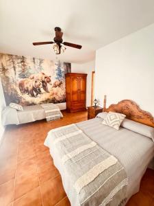 a bedroom with two beds and a painting on the wall at La Osera in Arroyo Frio