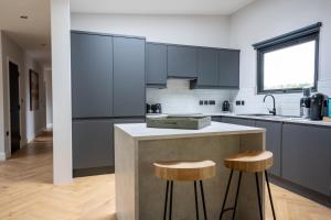 a kitchen with a counter and two stools at Landal Barnsoul in Shawhead