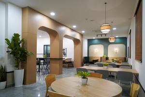Un comedor con mesas y sillas y un escritorio. en Olive Hotel Hitec City by Embassy Group, en Hyderabad
