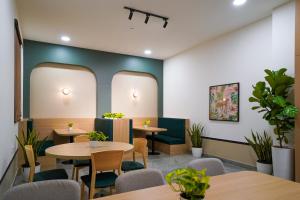 a restaurant with tables and chairs and plants at Olive Hotel Hitec City by Embassy Group in Hyderabad