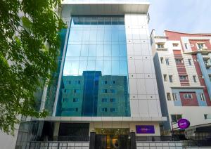 Un edificio alto con ventanas de vidrio en una ciudad. en Olive Hotel Hitec City by Embassy Group, en Hyderabad