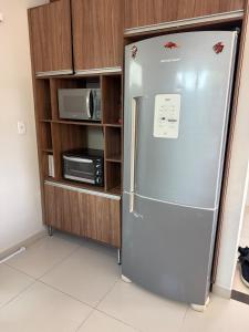 um frigorífico numa cozinha ao lado de um micro-ondas em Casa completa com dois quartos e uma suíte master, localizada no bairro Alphaville Fazendinha em Macapá