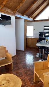 a large room with wooden tables and a kitchen at El Fortín de los Choros, un descanso para la familia in Los Choros +4 photos