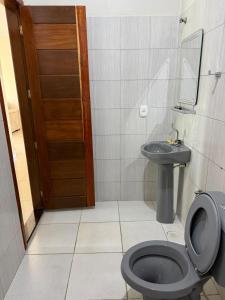 um banheiro com um vaso sanitário preto e uma pia em Casa completa com dois quartos e uma suíte master, localizada no bairro Alphaville Fazendinha em Macapá