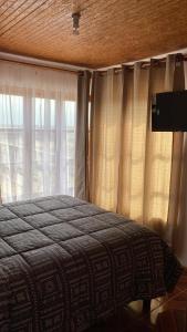 a bedroom with a bed and a window with curtains at El Fortín de los Choros, un descanso para la familia in Los Choros