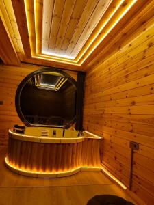 ArdeşenにあるElite Bungalovの木の壁に丸い浴槽がある部屋