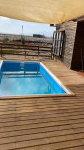 a swimming pool on top of a wooden deck at El Fortín de los Choros, un descanso para la familia in Los Choros