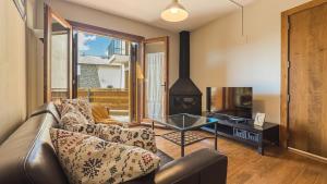 un soggiorno con un divano e una TV di Chez Bonheur a Osséja