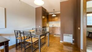 una cucina e una sala da pranzo con tavolo e sedie di Chez Bonheur a Osséja Altre 11 foto