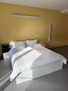 a large white bed with white sheets and pillows at Modern studio Belval in Esch-sur-Alzette +5 photos