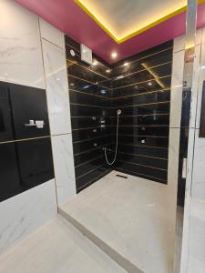 ein Badezimmer mit Dusche mit schwarz-weißen Fliesen in der Unterkunft Malathi Residency in Arumuganeri