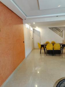 a dining room with yellow chairs and a table at Maison Duplex in Sale