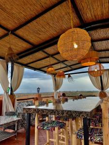 einen Tisch und Stühle unter einem Dach mit Kronleuchtern in der Unterkunft Tynass Ferme in Fès + 4 Fotos