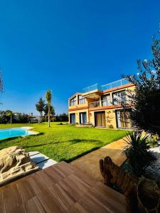 ein großes Haus mit einem Garten mit Pool in der Unterkunft Tynass Ferme in Fès