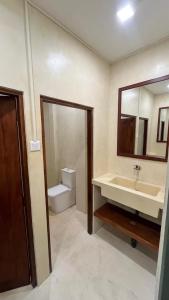 a bathroom with a sink and a toilet and a mirror at Kabalana Surf Hostel in Ahangama