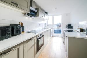 a kitchen with white counters and a large window at Spacious 2 Bedroom Apartment, Free Parking, WiFi in Gloucester