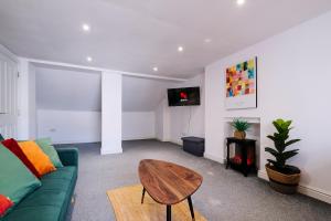 a living room with a green couch and a table at Spacious 2 Bedroom Apartment, Free Parking, WiFi in Gloucester