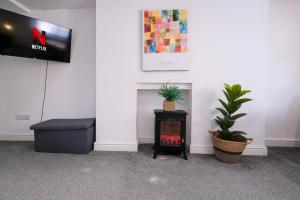 a living room with a fire place and a tv at Spacious 2 Bedroom Apartment, Free Parking, WiFi in Gloucester +5 photos