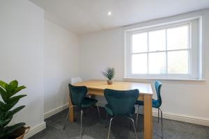 a table and chairs in a room with a window at Spacious 2 Bedroom Apartment, Free Parking, WiFi in Gloucester