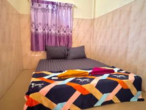 a bedroom with a bed with a colorful blanket on it at The Panda Backpacker Hostel in Kampot