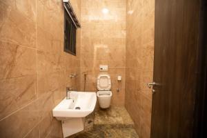 a bathroom with a white toilet and a sink at Luxury 4 bedroom Duplex with a pool in Mama +23 photos