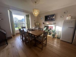 una sala da pranzo con tavolo e frigorifero di Cartrefle - A Charming Welsh Escape perfect for families a St Clears