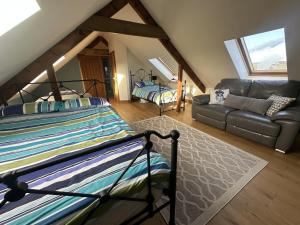 Camera mansardata con 2 letti e un divano. di Cartrefle - A Charming Welsh Escape perfect for families a St Clears