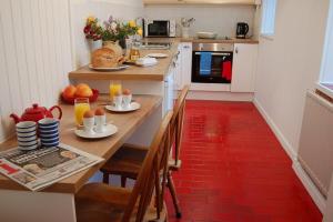 cocina con mesa de madera con sillas y comedor en The Rest, en St Ives