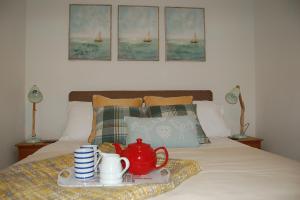 Una cama con una bandeja con un juego de té encima. en The Rest, en St Ives