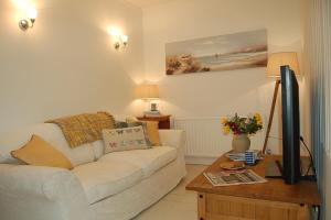 Una sala de estar con un sofá blanco y una mesa. en The Rest, en St Ives