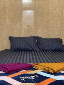a bed with blankets and pillows on the floor at The Panda Backpacker Hostel in Kampot +13 photos