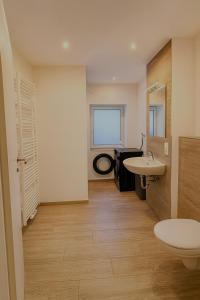 ein Badezimmer mit Waschbecken und Toilette in der Unterkunft Stadtzentrum Apartment - Modern & Ruhig in Quakenbrück