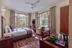 un dormitorio con una cama y un escritorio en una habitación en Shingar Regency, en Manali 196 fotos más