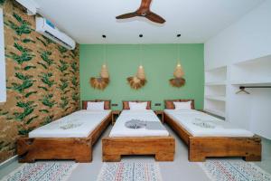 due letti in una stanza con pareti verdi di Ô TALIA Hôtel and SPA a Nungwi Altre 95 foto